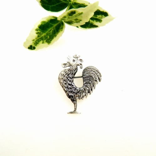 Broszka srebrna z małym kogutem.